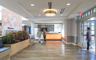 Custom graphic screens and banquette separates new entryway from atrium